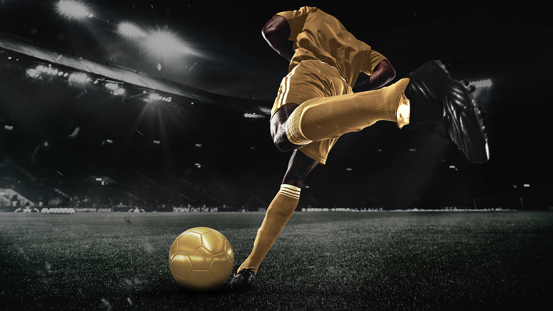 Footballer in gold kit kicking a gold football on a pitch.