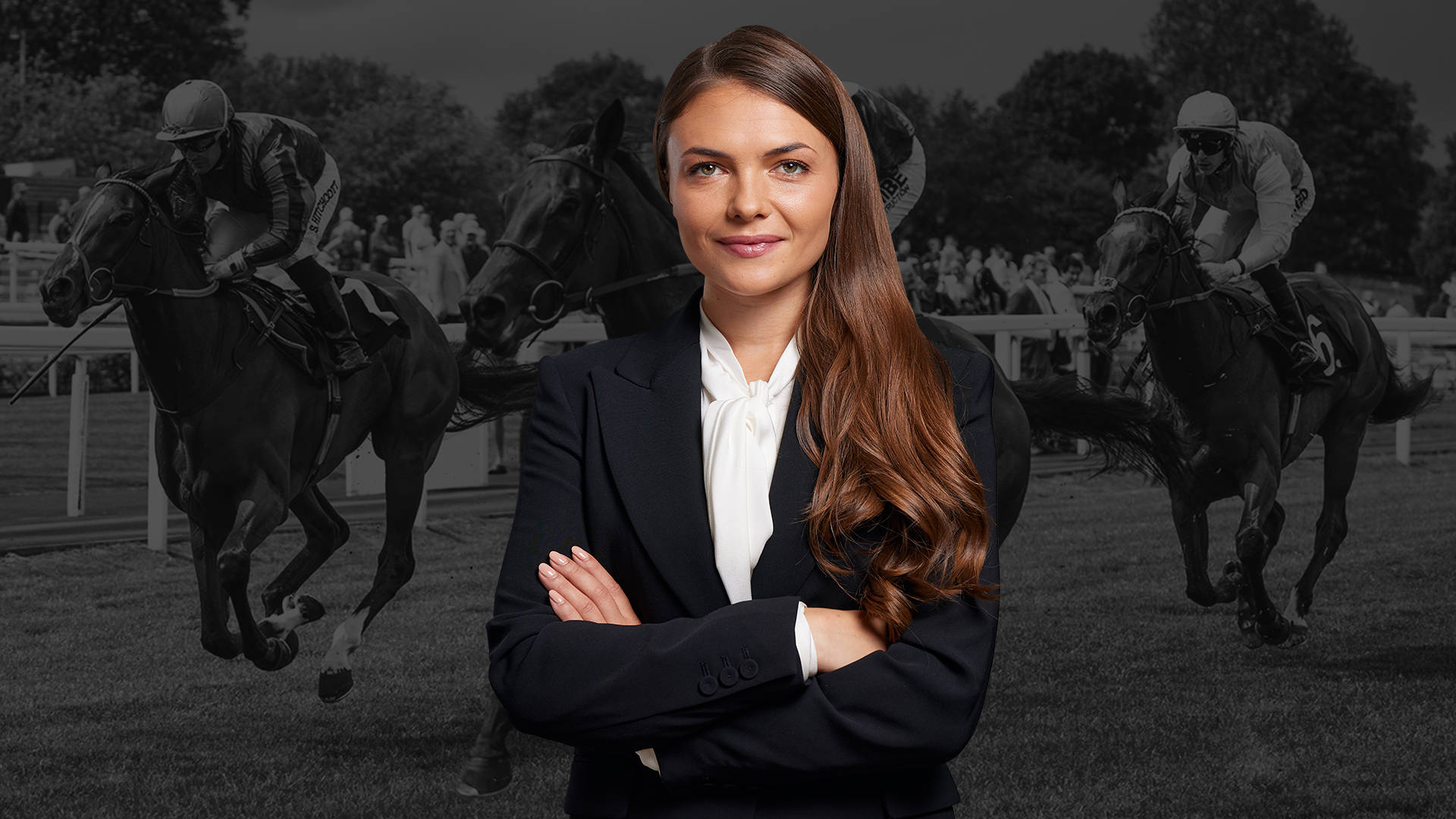 Woman in a suit with horse racing in the background.
